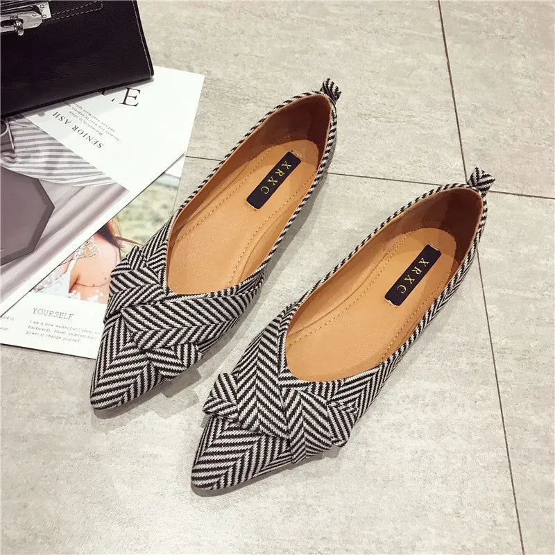 Women's black pointed toe cotton flats with a low flat heel and shallow mouth design on a white background.
