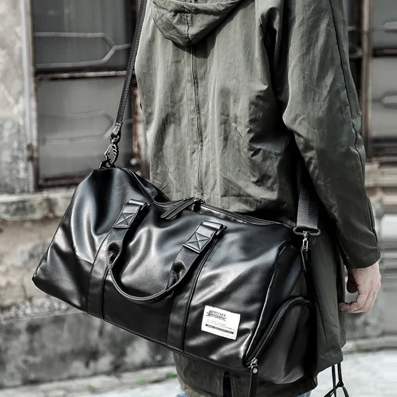 Large black PU leather sports training bag with a shoulder strap, shown with internal organiser pockets for a laptop and camera.