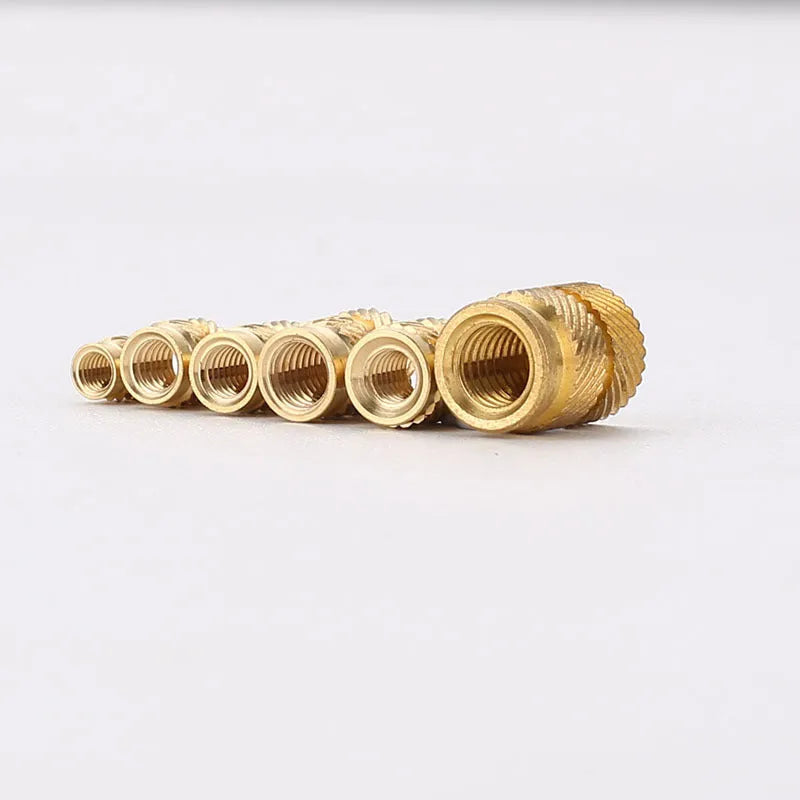 Assortment of brass hot melt copper nuts with M2 and M3 threads in various heights.