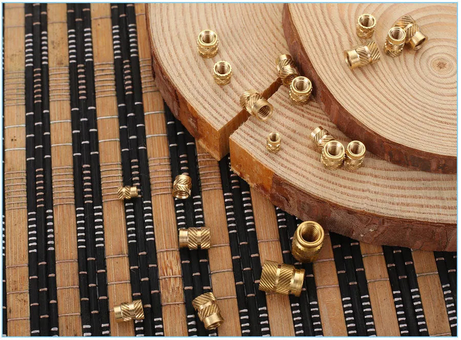 Assortment of brass hot melt copper nuts with M2 and M3 threads in various heights.