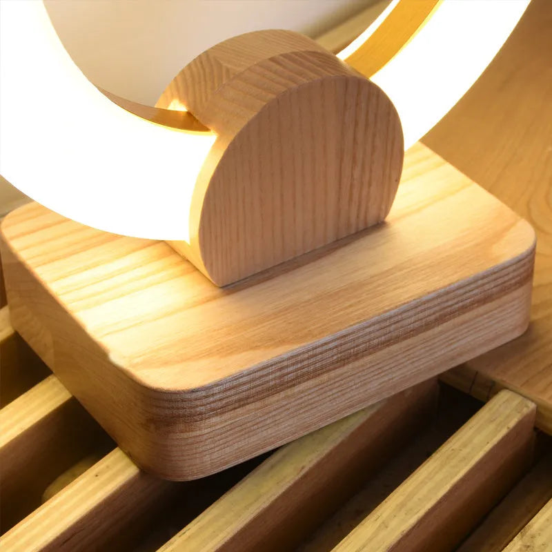 Nordic style wooden circular art chandelier with round acrylic shade in a modern living room.