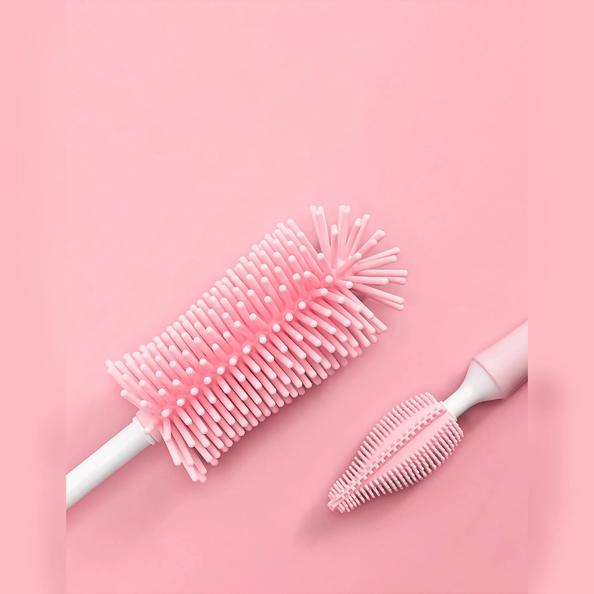 Blue, pink, and yellow silicone baby bottle brushes with an integrated straw cleaning tool.