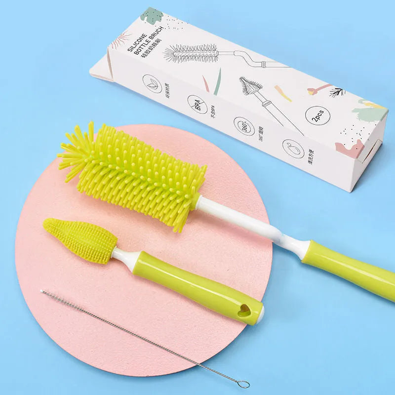 Blue, pink, and yellow silicone baby bottle brushes with an integrated straw cleaning tool.