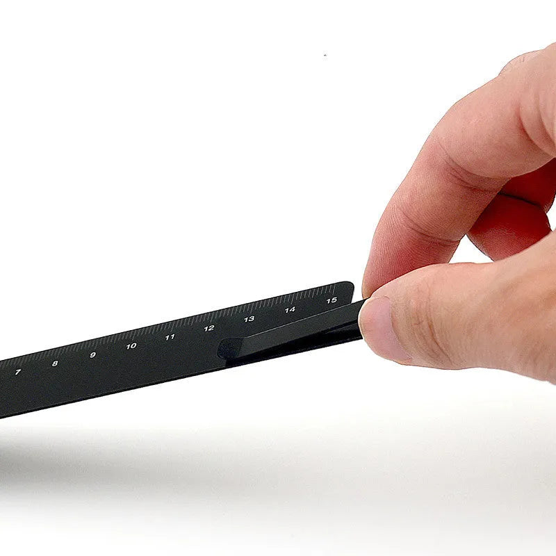 RUMA black and silver aluminium bookmark ruler showing 15cm laser-engraved scale.