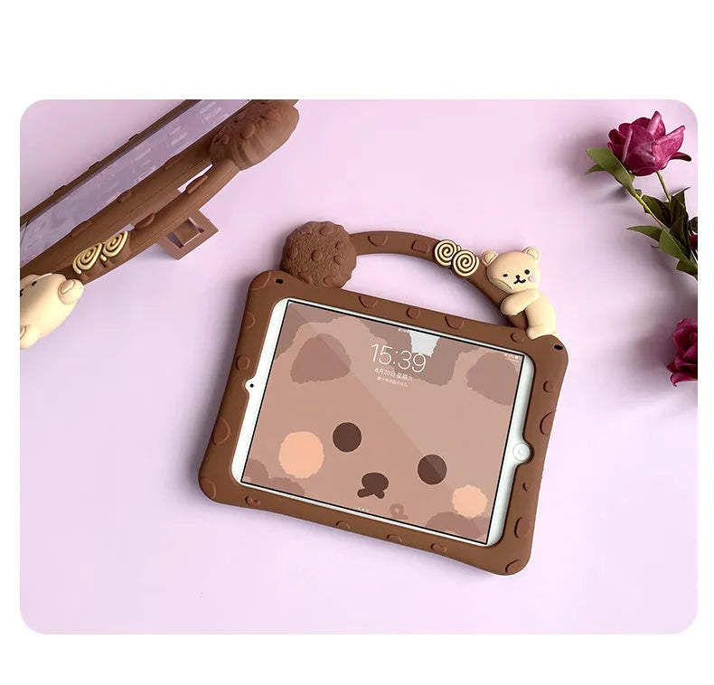 Brown cartoon-design silicone sleeve for an iPad tablet, shown with its integrated fold-out viewing bracket.