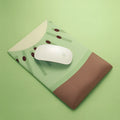 Green kiwi-shaped mouse pad with integrated wrist support and printed calculator numbers on cloth surface.
