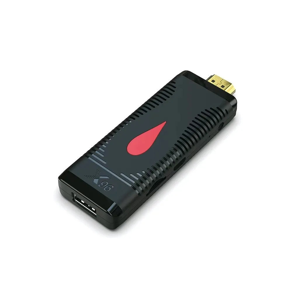 Smart network TV set-top box stick dongle with remote control and power supply on table