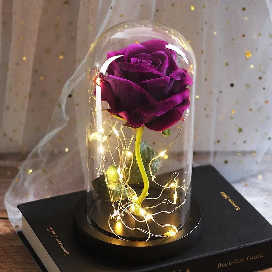 LED illuminated silk rose bouquet in a glass dome on a wooden base, with warm white lights.