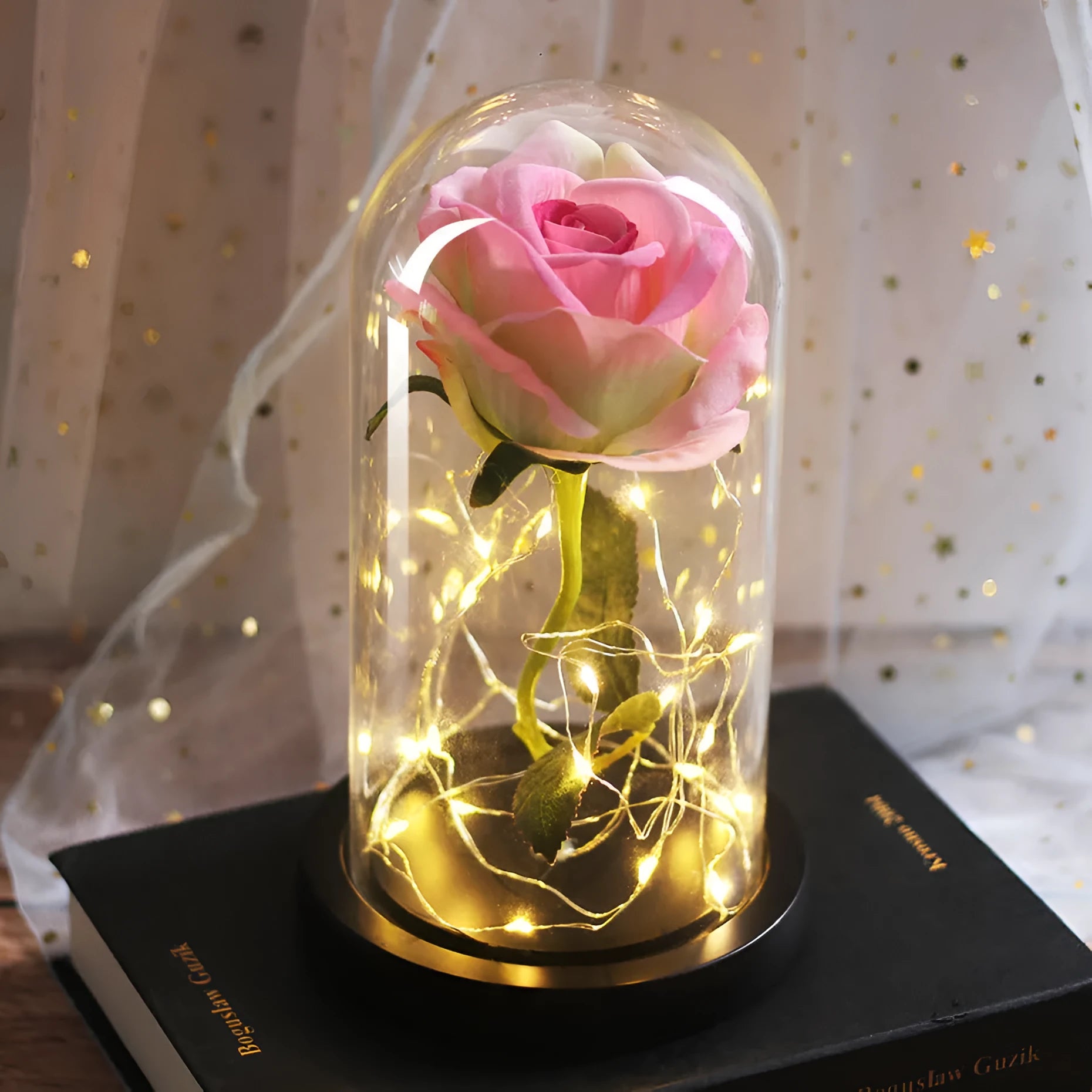 LED illuminated silk rose bouquet in a glass dome on a wooden base, with warm white lights.