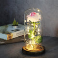 LED illuminated silk rose bouquet in a glass dome on a wooden base, with warm white lights.