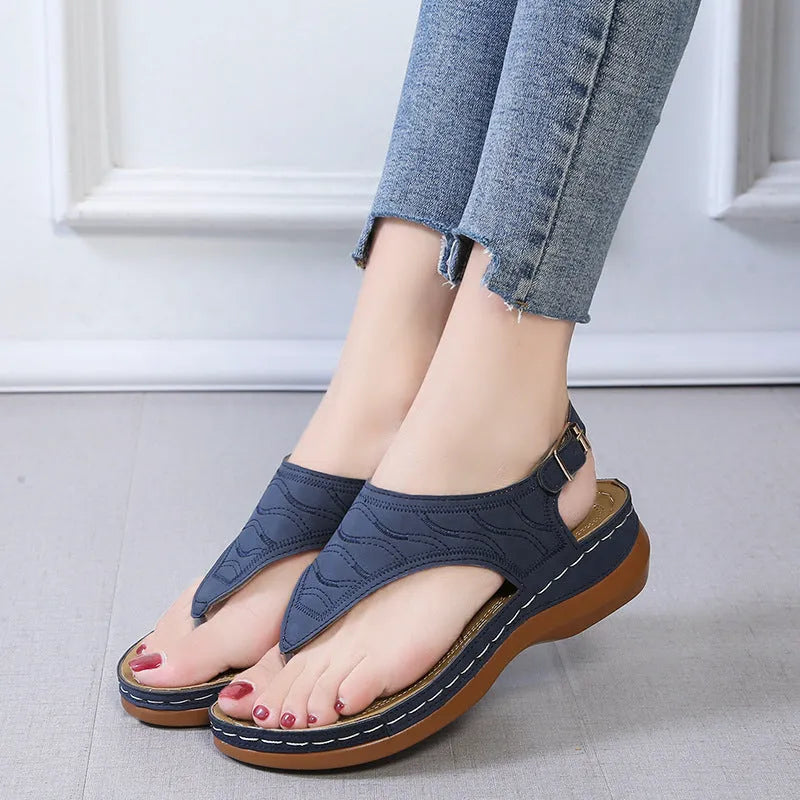Women's wedge heel flip flop sandals in black with an adjustable buckle strap on the back.