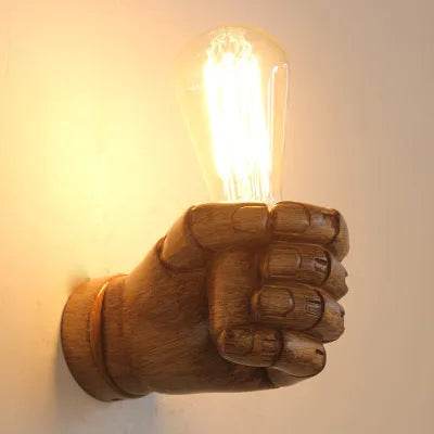 Industrial-style resin fist wall lamp in black, white, or wood grain finish for decorative lighting.