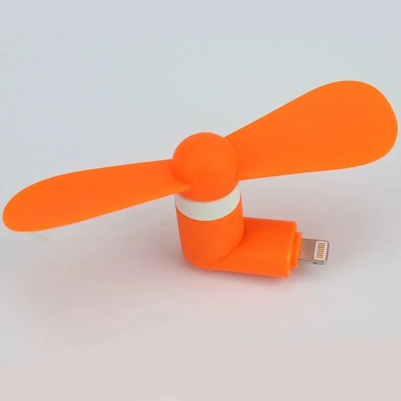 Portable mobile phone mini fan with plastic blades in various colours attached to smartphone