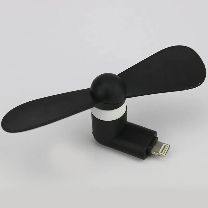 Portable mobile phone mini fan with plastic blades in various colours attached to smartphone