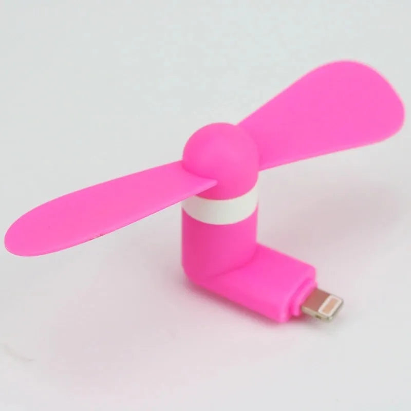 Portable mobile phone mini fan with plastic blades in various colours attached to smartphone