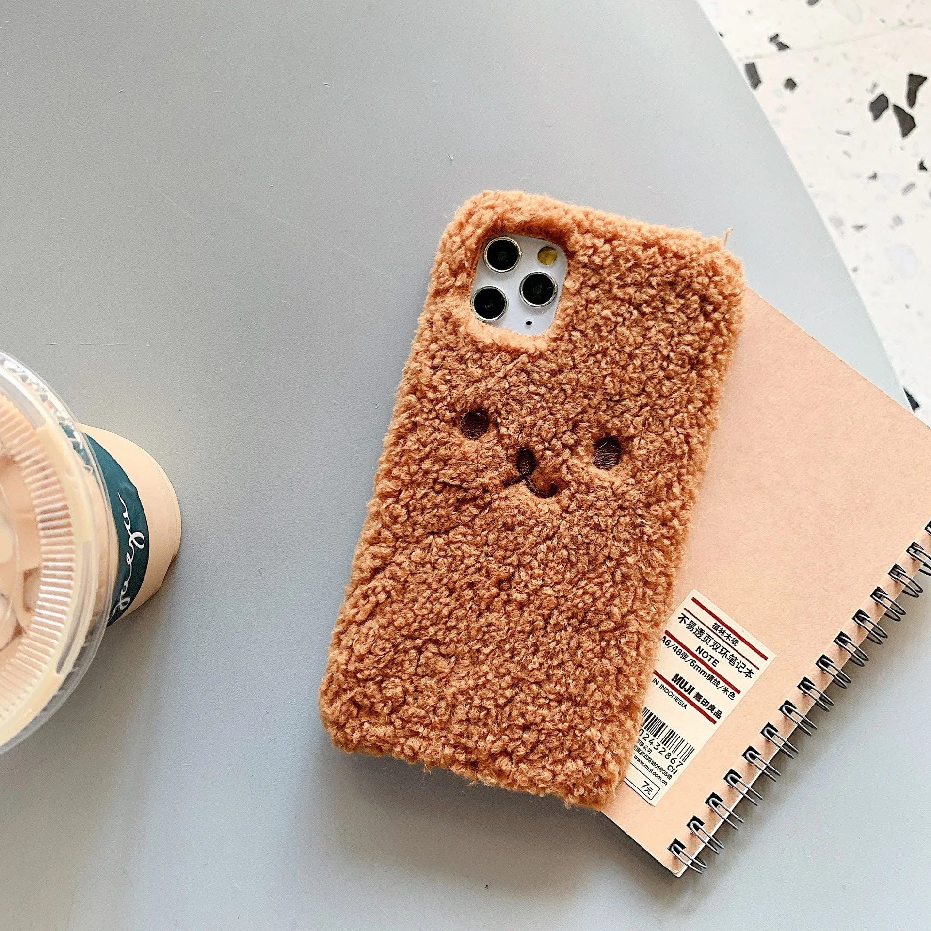 Brown embroidered plush cartoon bear face on a soft TPU iPhone case