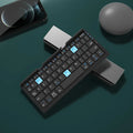 Silver aluminium folding Bluetooth keyboard open with phone on stand next to folded size comparison