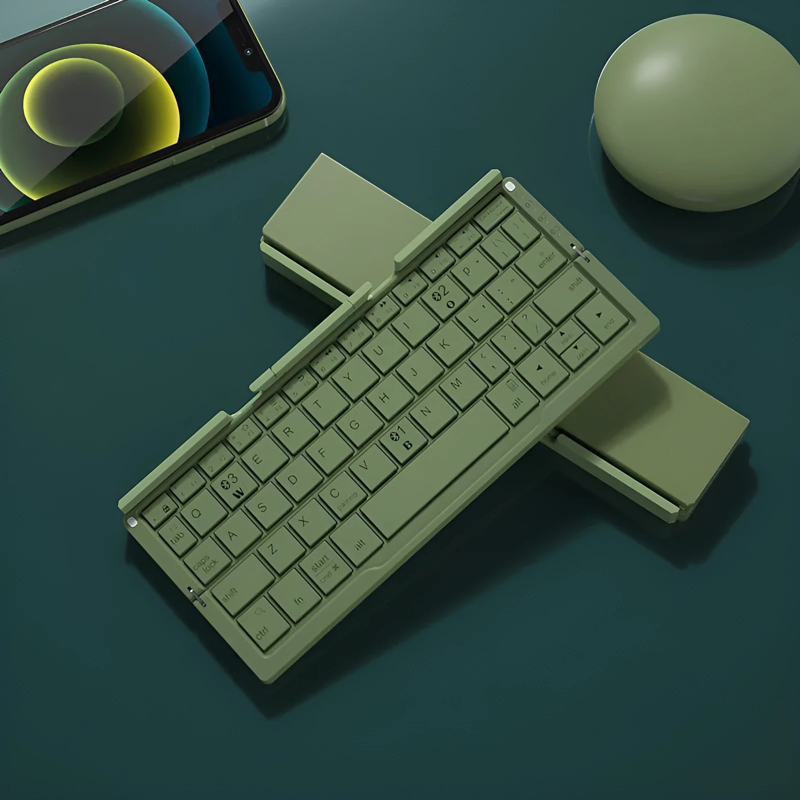 Silver aluminium folding Bluetooth keyboard open with phone on stand next to folded size comparison