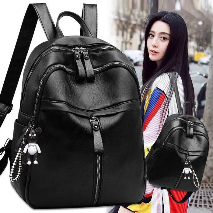 Black soft-surface leather backpack with 24-litre capacity showing ID pocket and luggage strap attachments