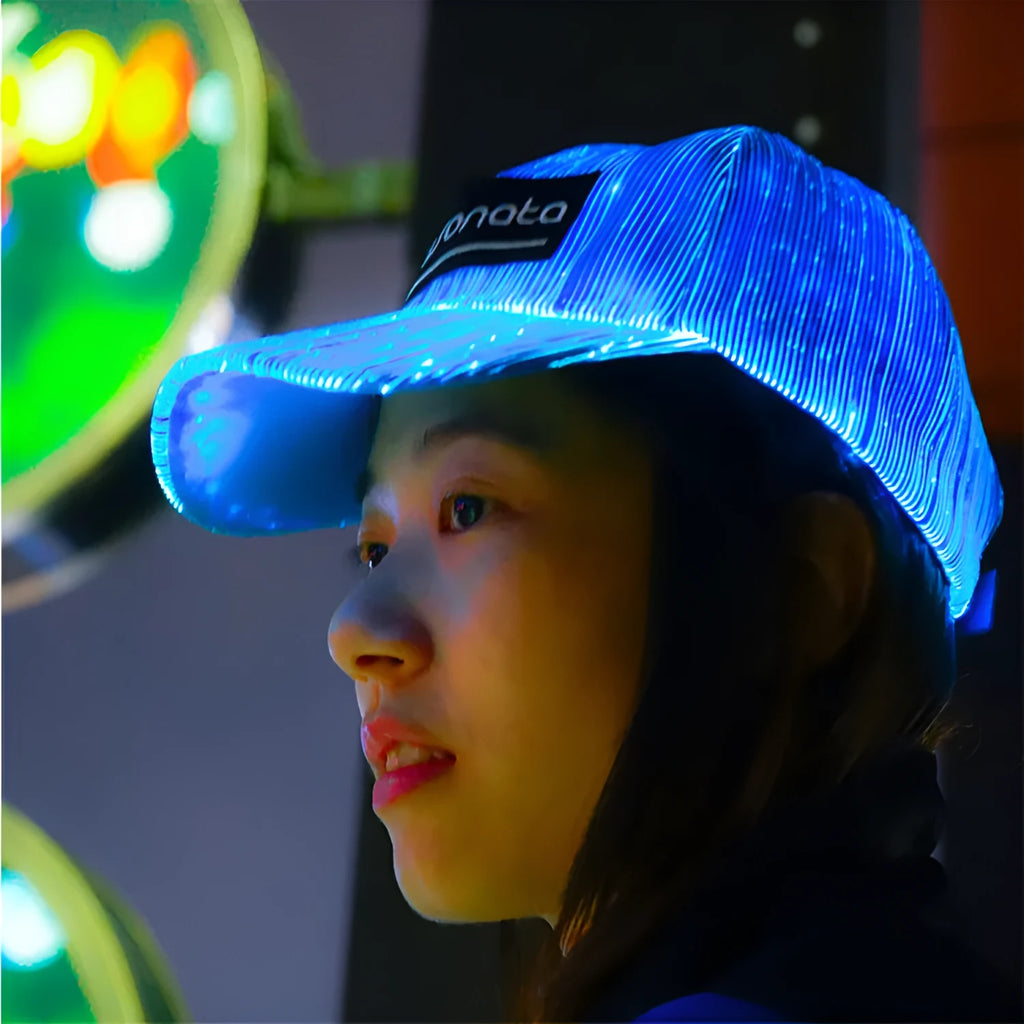 White luminous baseball cap with fibre optic fabric and LED glow against dark background