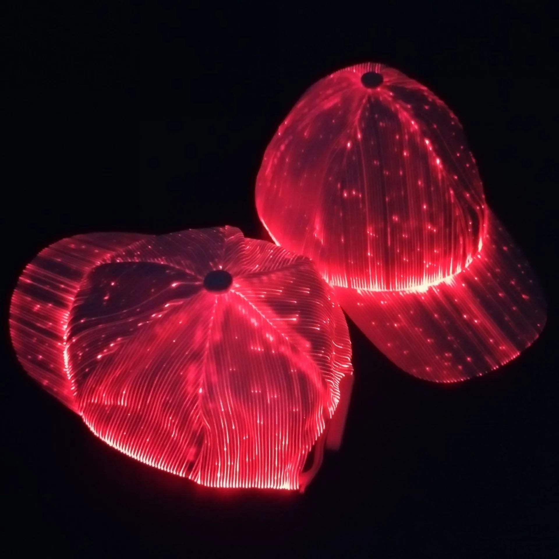 White luminous baseball cap with fibre optic fabric and LED glow against dark background