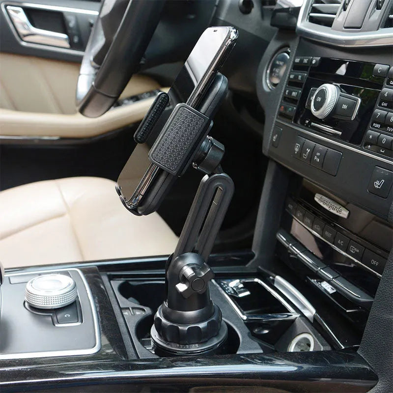 Black ABS car phone holder mounted on a dashboard, showing 360-degree rotation and soft foam contact pads.