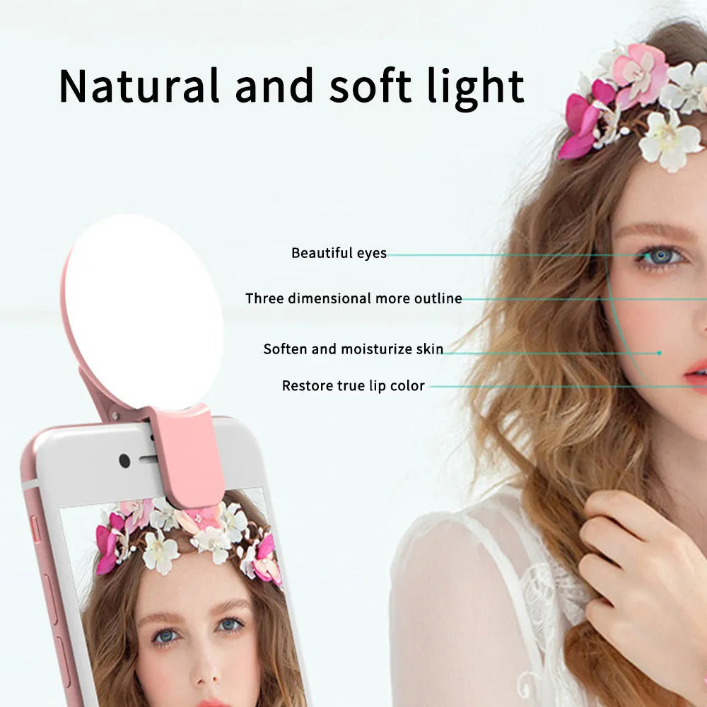 Small round white LED fill light clipped to the top of a mobile phone.