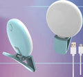 Small round white LED fill light clipped to the top of a mobile phone.