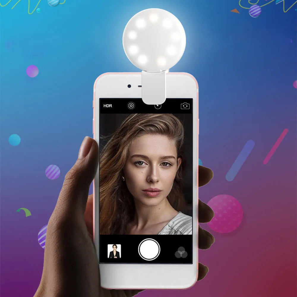 Small round white LED fill light clipped to the top of a mobile phone.