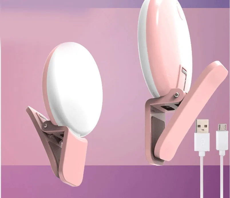 Small round white LED fill light clipped to the top of a mobile phone.