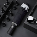 Automatic reverse folding umbrella with black canopy, plastic handle, shown open and closed.