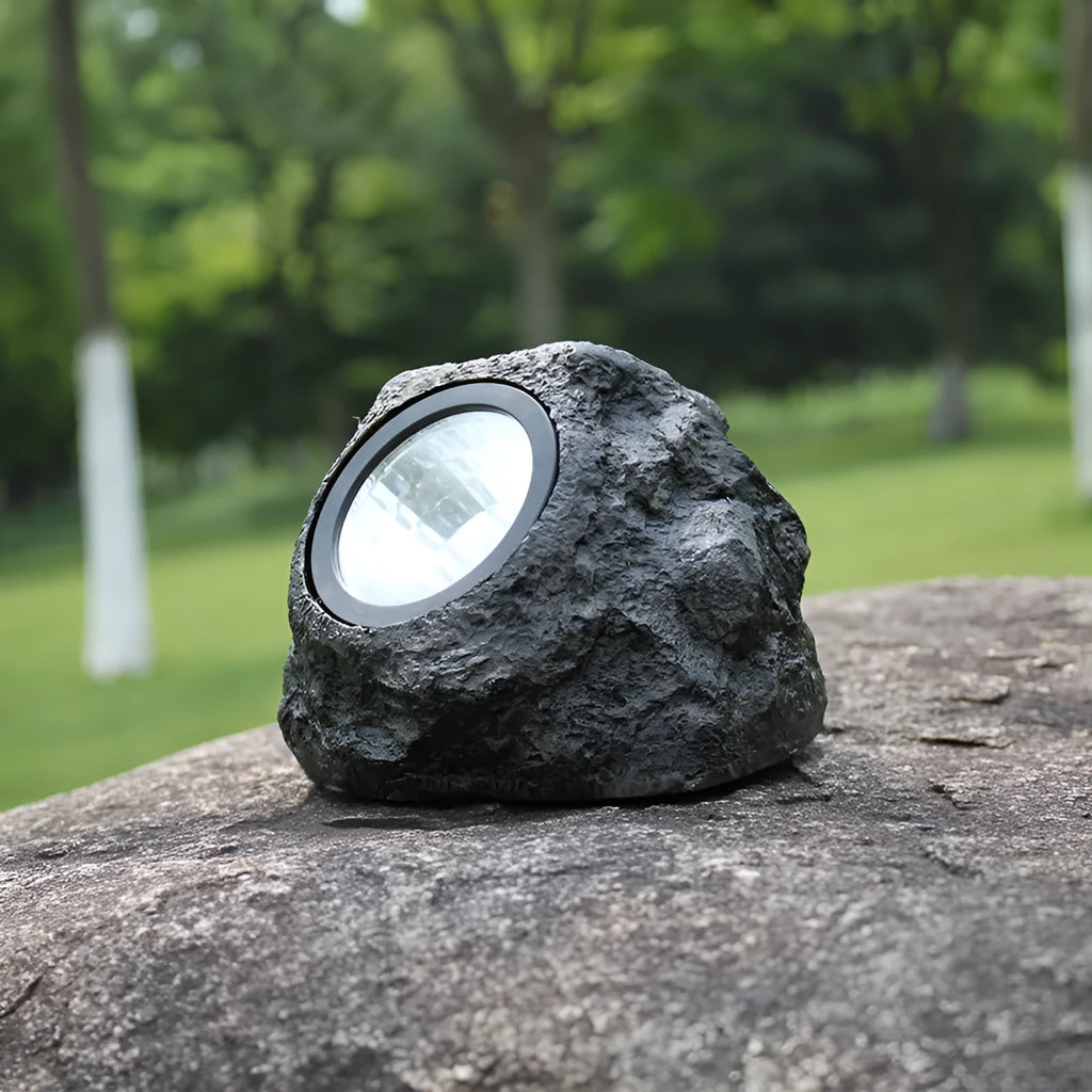 Black solar lamp with simulation stone exterior in outdoor garden setting, IP65 rated LED light