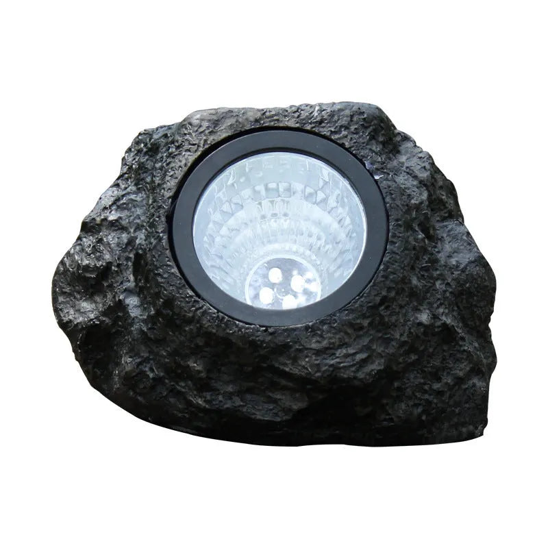 Black solar lamp with simulation stone exterior in outdoor garden setting, IP65 rated LED light
