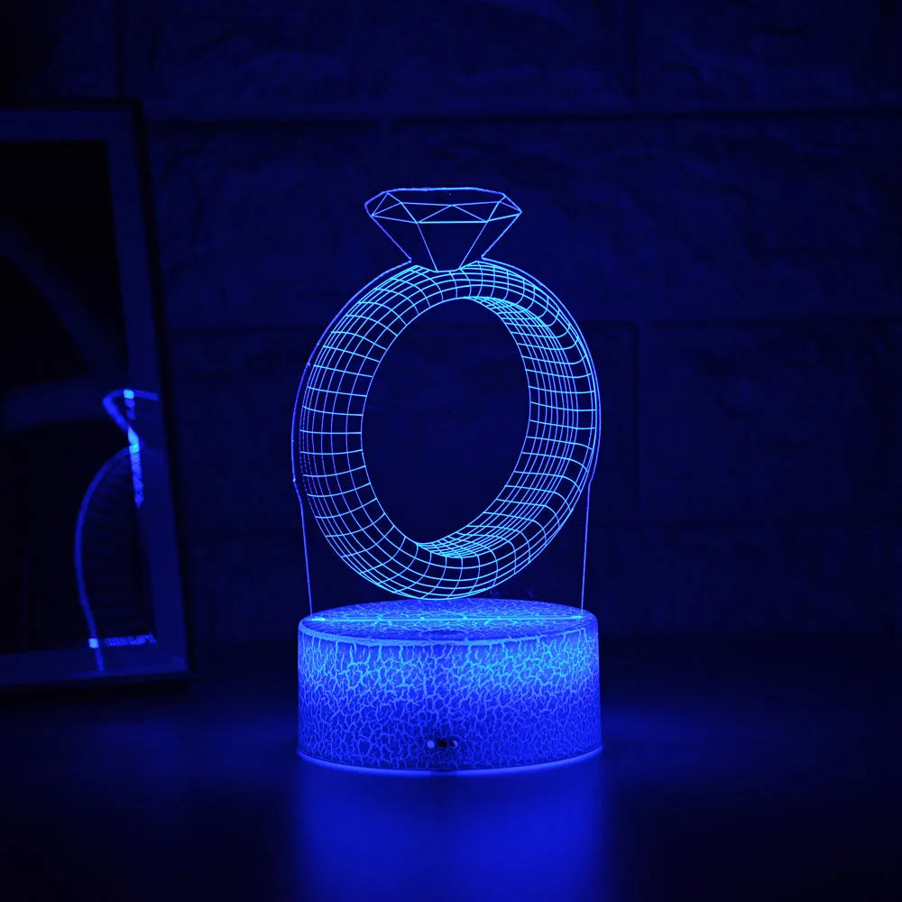 3D LED night light showing illuminated diamond ring design on a black background with colour-changing lights.