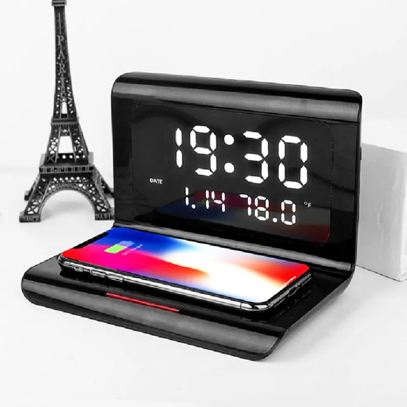 White wireless charging alarm clock showing calendar, temperature display, and phone charging on surface