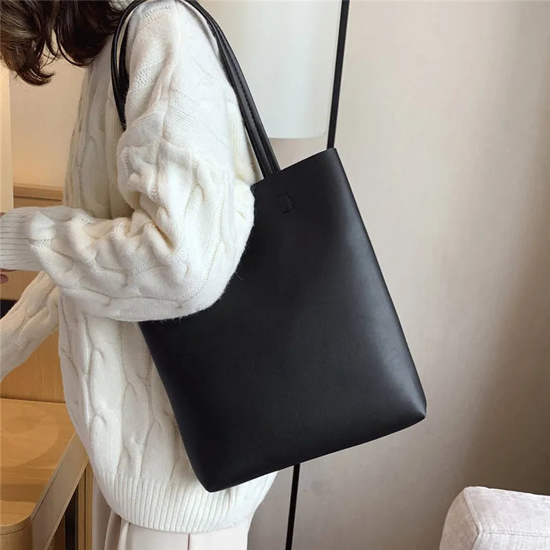 Large-capacity portable tote bag in Black with plain car suture design, soft handle, and single shoulder strap