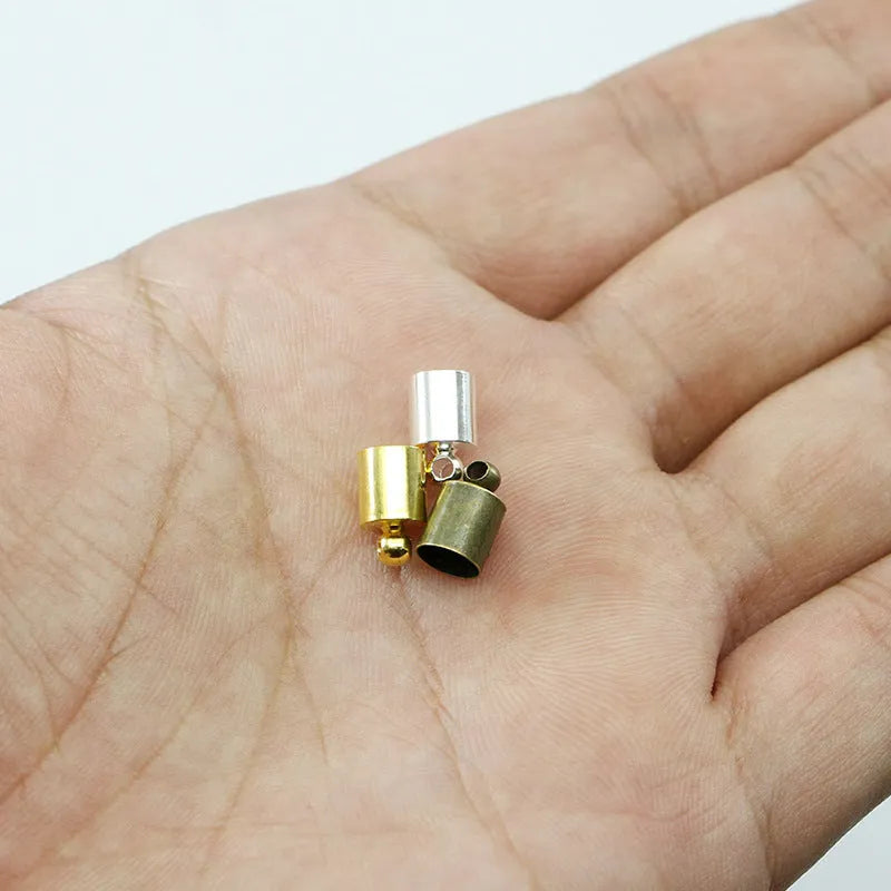 Assorted copper caps for jewellery making in gold, silver, bronze and black finishes, showing size variation.