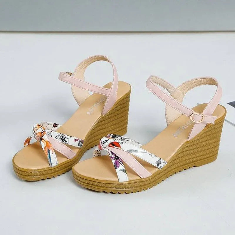 Pink women's wedge sandals with a fish mouth design and buckle strap on a non-slip sole.