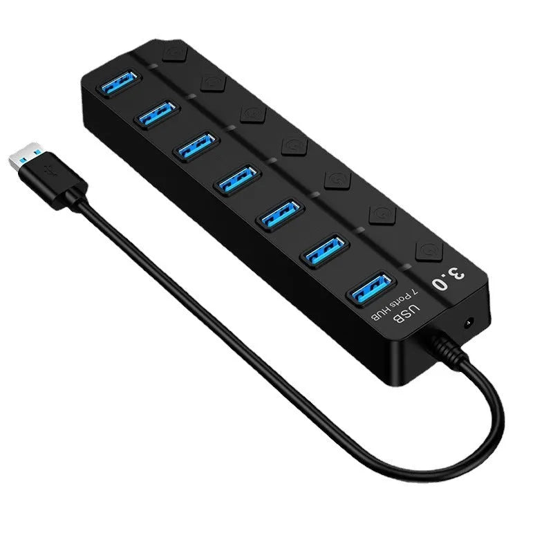 Black 7-port high-speed USB 3.0 hub with external power adapter on a desk.