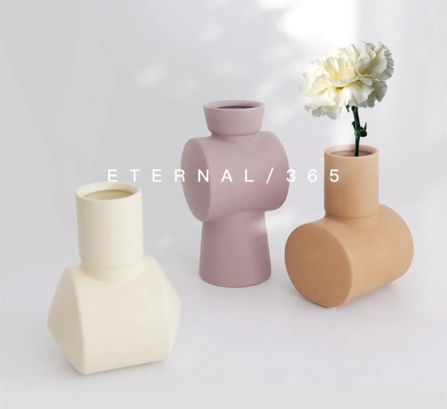 Nordic style Morandi ceramic vase with colour glaze in beige, brown, or purple on a wooden surface.