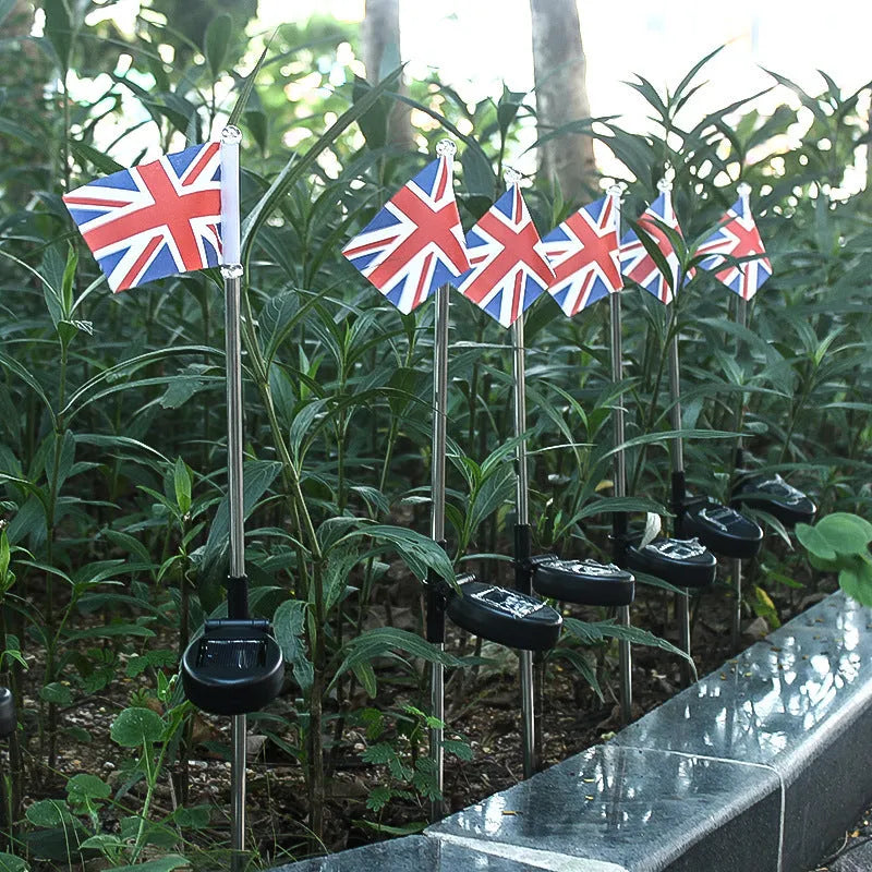 White solar-powered garden flag light showing American flag design on stainless steel pole.