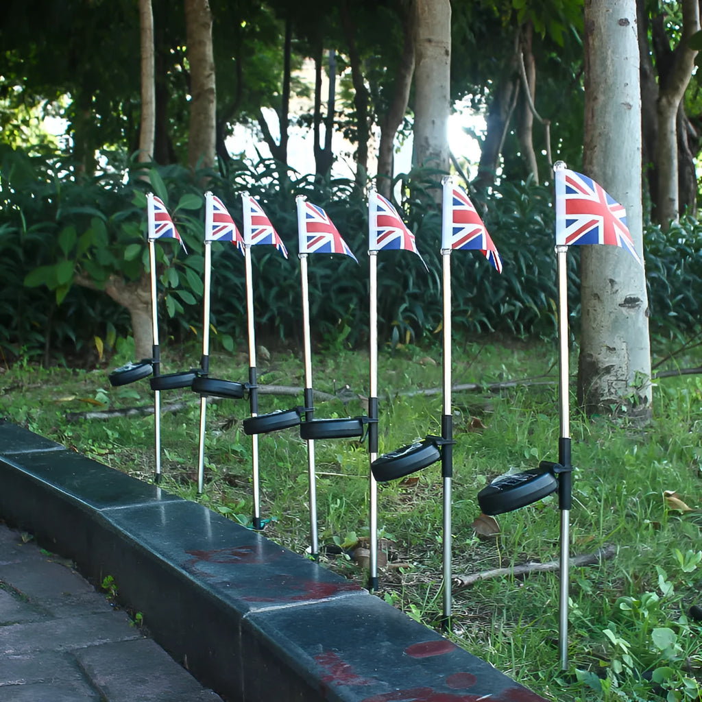 White solar-powered garden flag light showing American flag design on stainless steel pole.