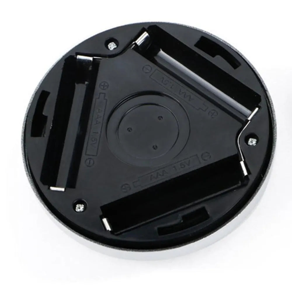 Silver circular battery-powered motion sensor night light on a surface.
