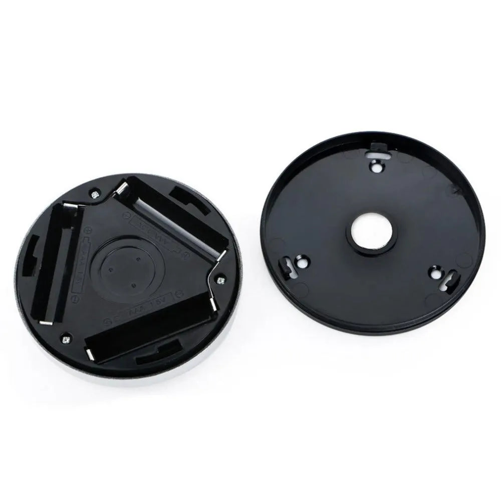 Silver circular battery-powered motion sensor night light on a surface.