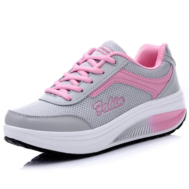 Women's grey powder heelless sports travel shoes with a mid heel on a plain background