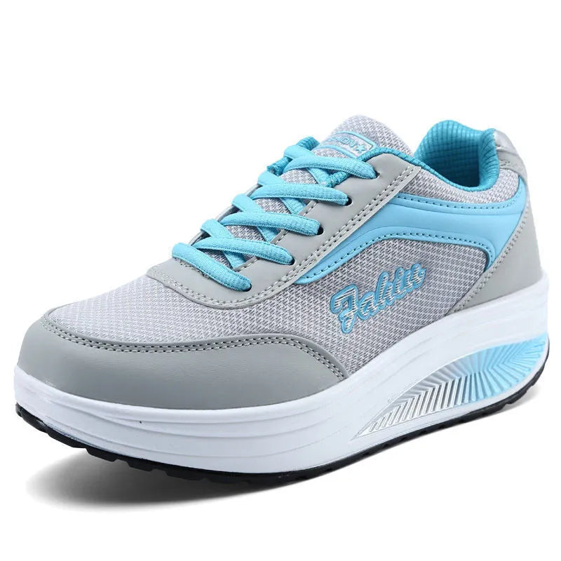 Women's grey powder heelless sports travel shoes with a mid heel on a plain background