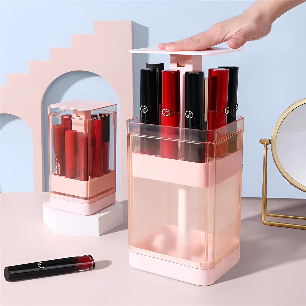 Pink press-lift lipstick storage box with dust cover open, showing 12 organised compartments.