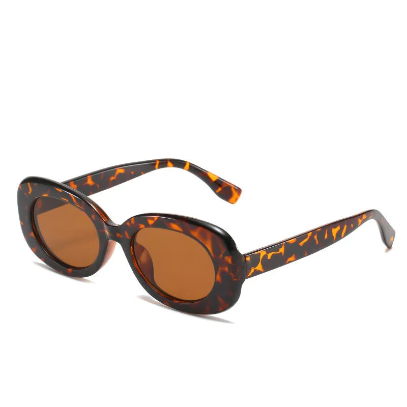 Oval fashion sunglasses for women with black PC frame and UV400 AC lenses