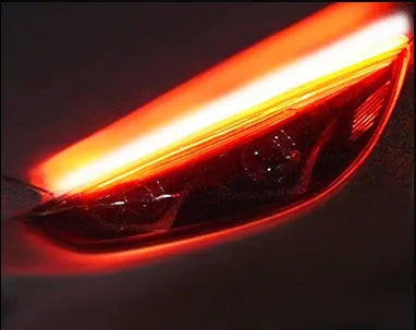 Flexible silicone car LED daytime running light strip with flowing turn signal functionality mounted on vehicle headlight