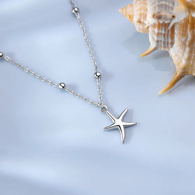 Women's sterling silver S925 anklet with a starfish charm and round bead on an adjustable chain.